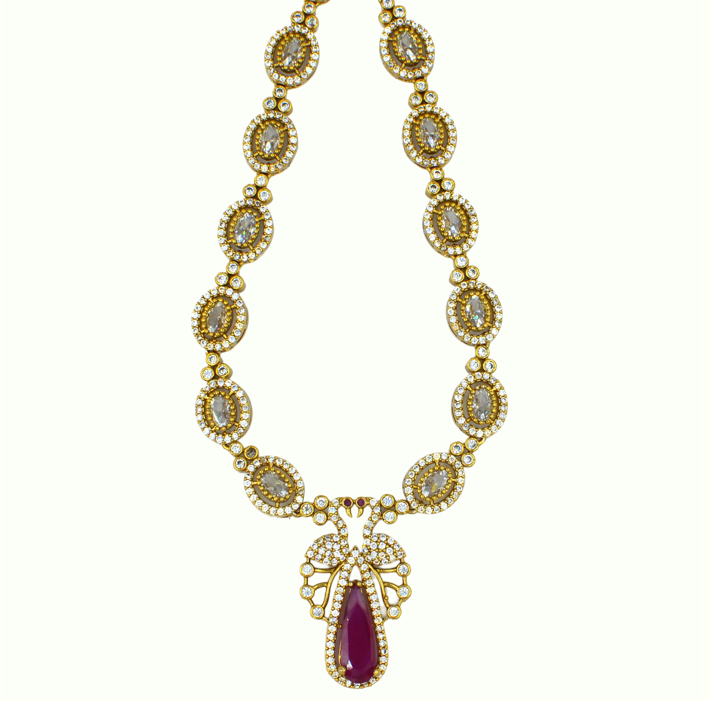 The Nila Gold Plated Peacock Design Crystal Necklace with Teardrop Ruby Drop Earrings