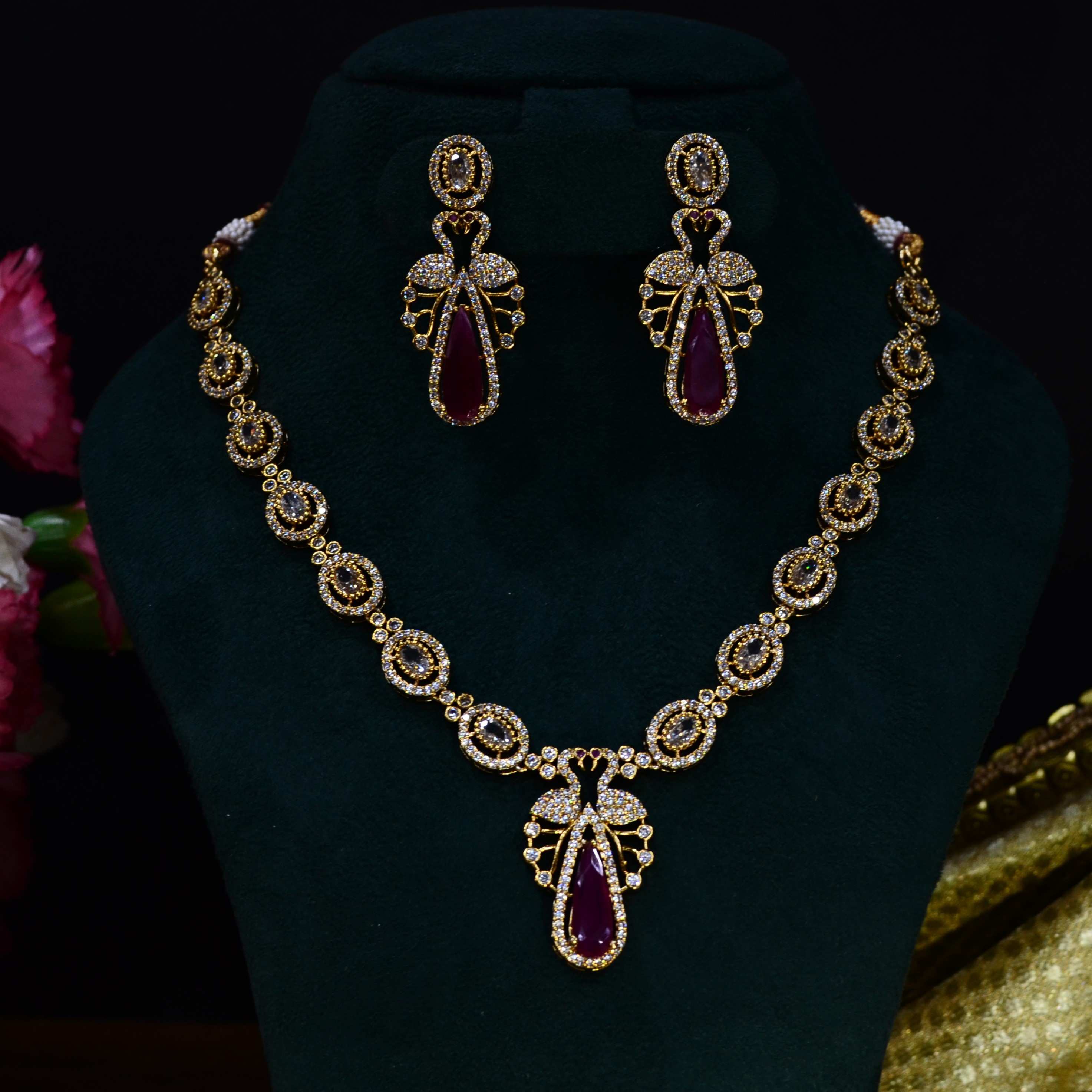 The Nila Gold Plated Peacock Design Crystal Necklace with Teardrop Ruby Drop Earrings
