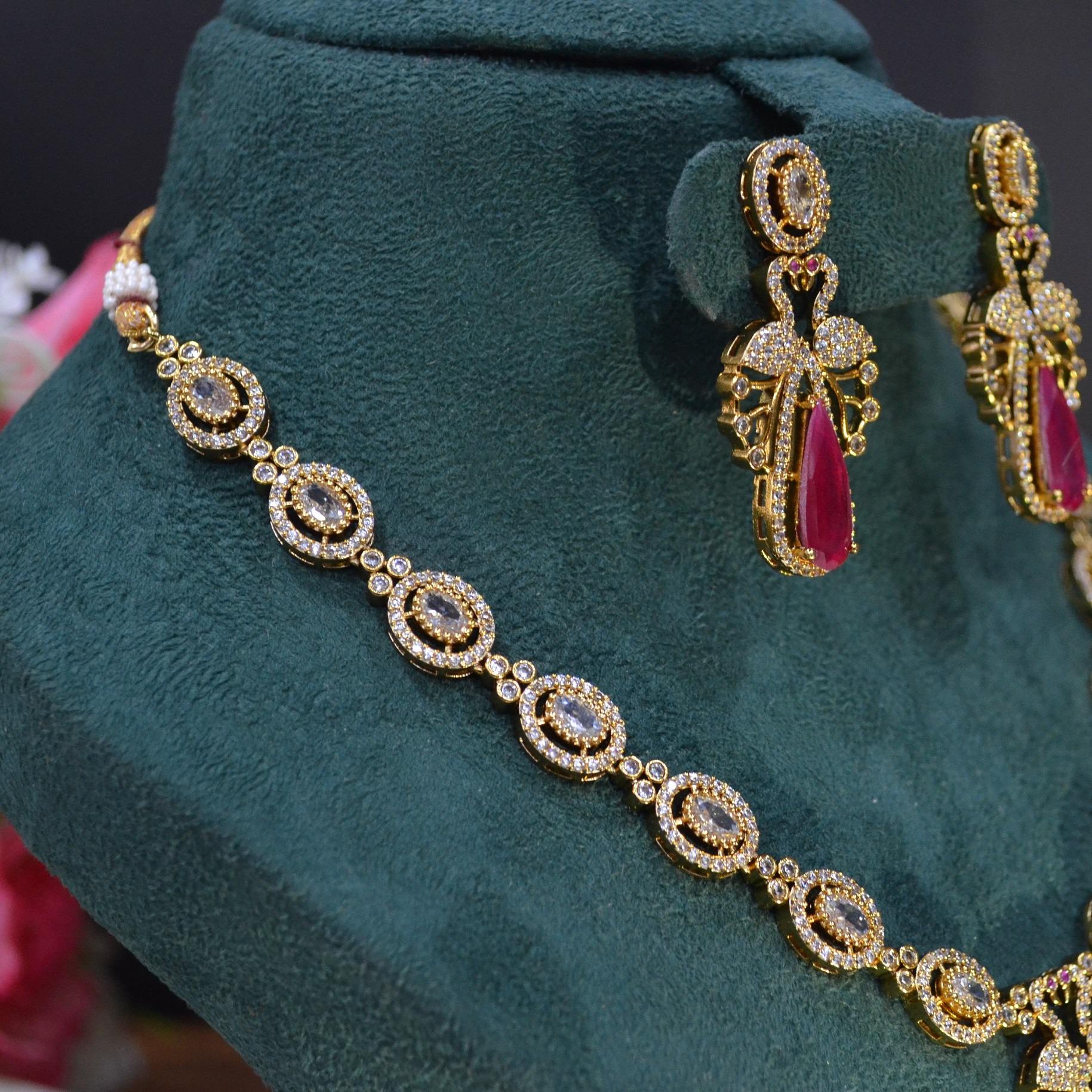 The Nila Gold Plated Peacock Design Crystal Necklace with Teardrop Ruby Drop Earrings