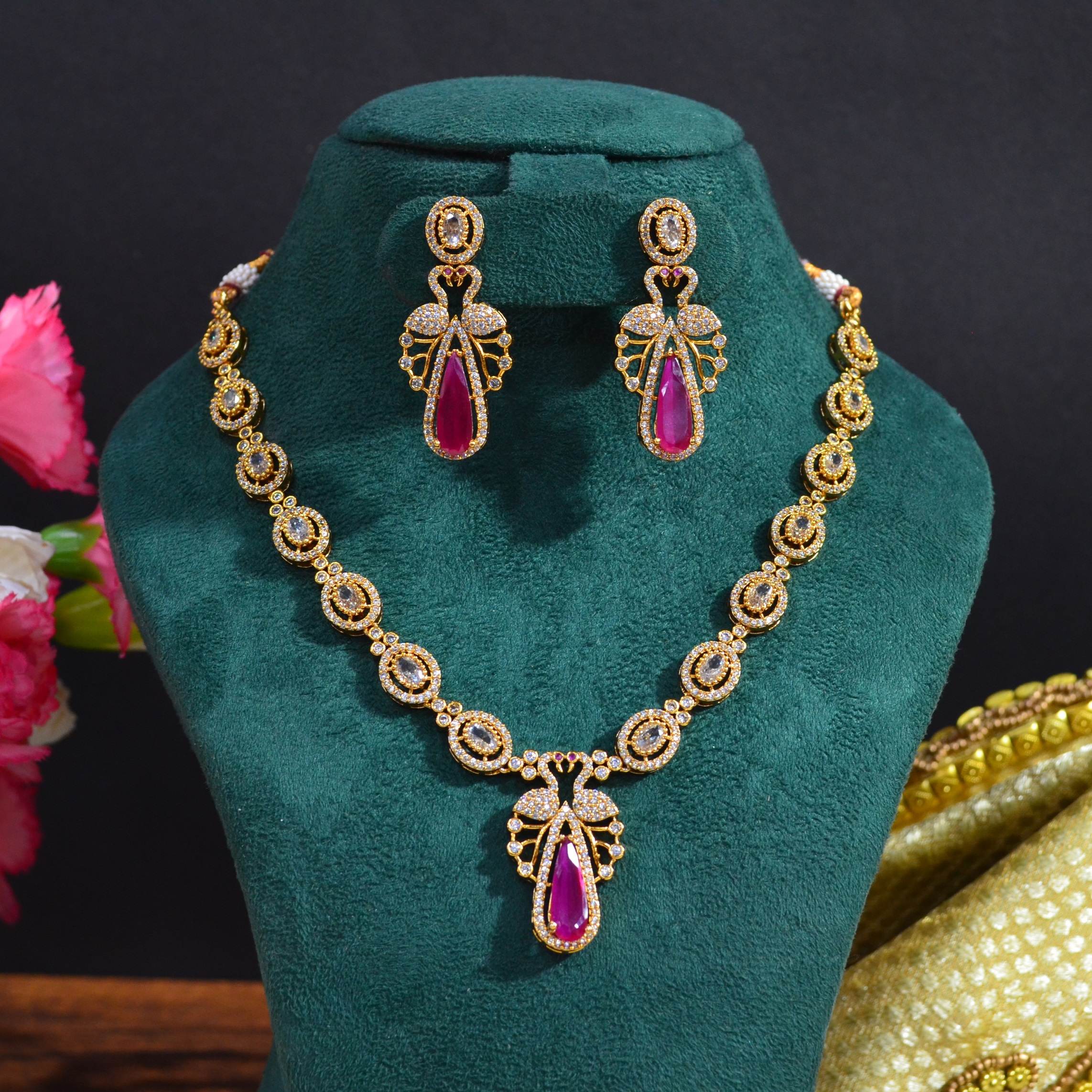 The Nila Gold Plated Peacock Design Crystal Necklace with Teardrop Ruby Drop Earrings