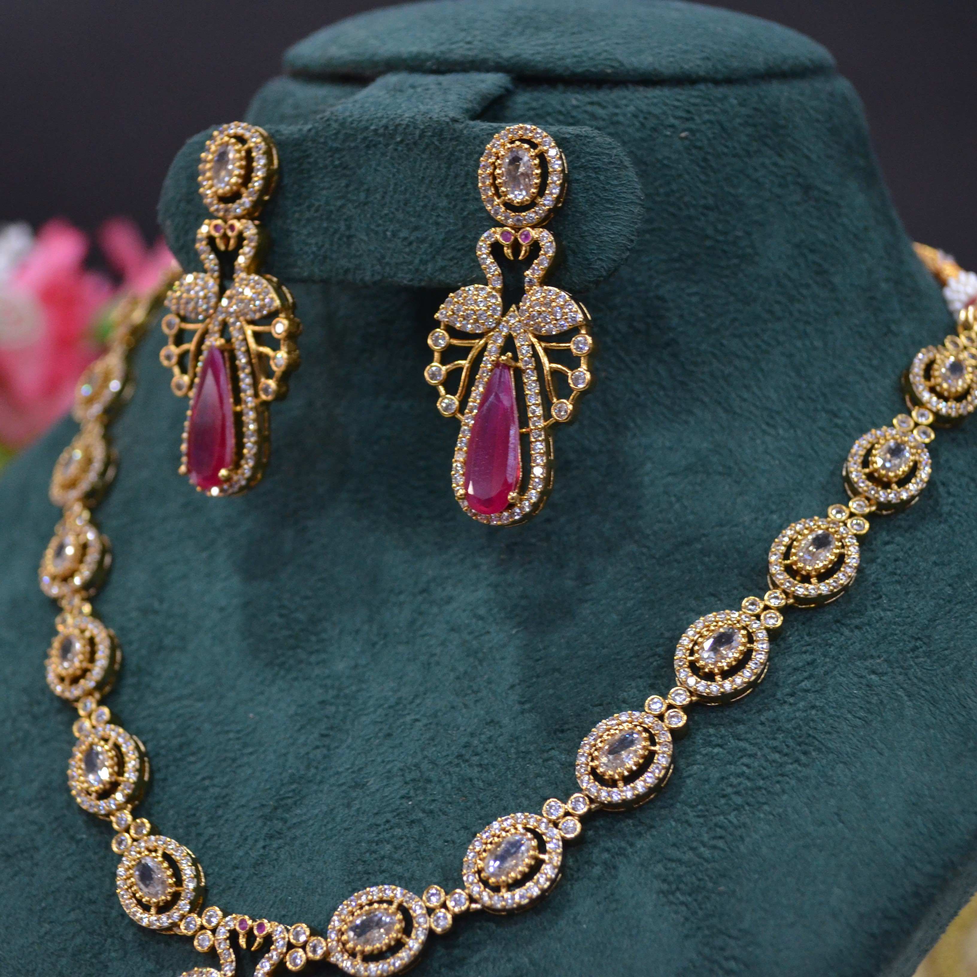 The Nila Gold Plated Peacock Design Crystal Necklace with Teardrop Ruby Drop Earrings