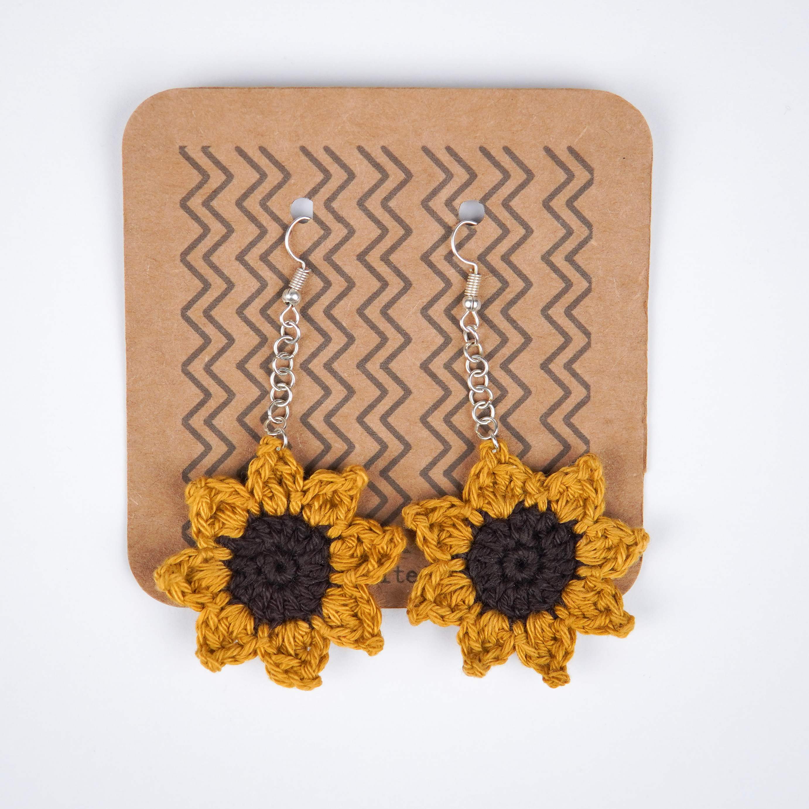 Close-up of AHG's Sunflower Crochet Earrings. Delicate details for a touch of summer.