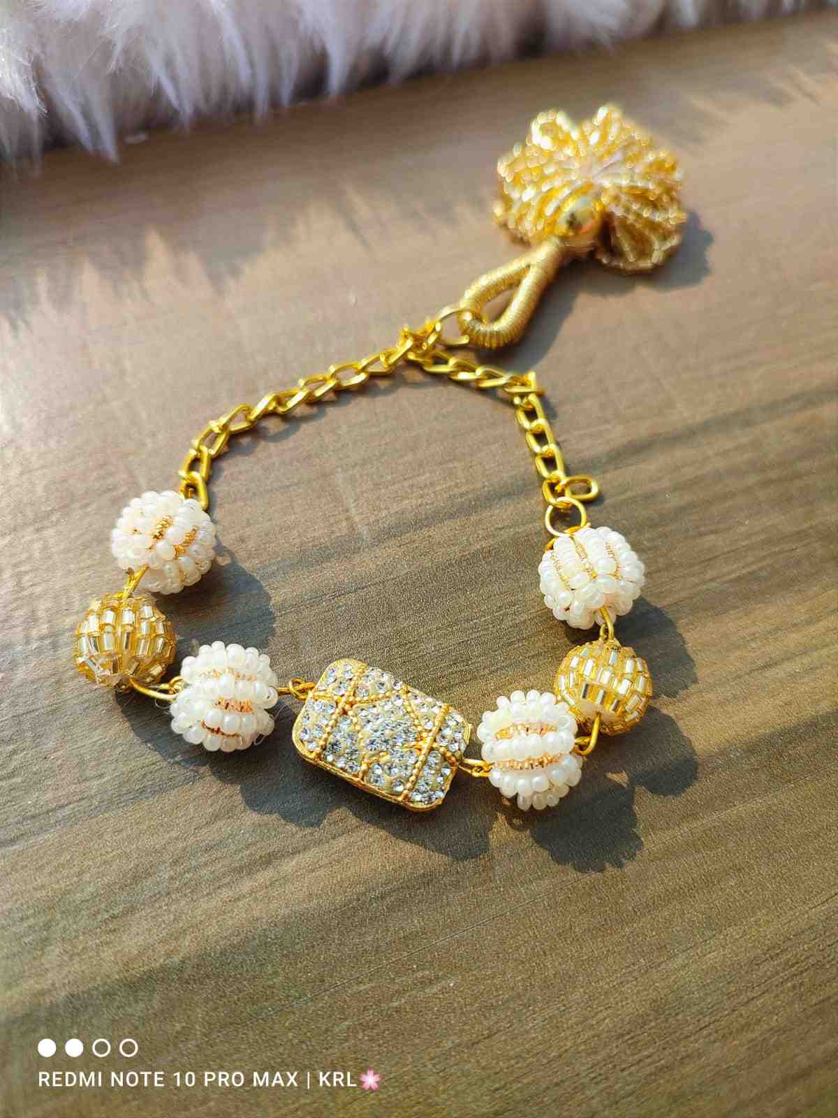 Elegant Pearl motif bracelet with stone embellished piece on the centre with a cute lil hanging . Comes with adjustable chain which fits to all