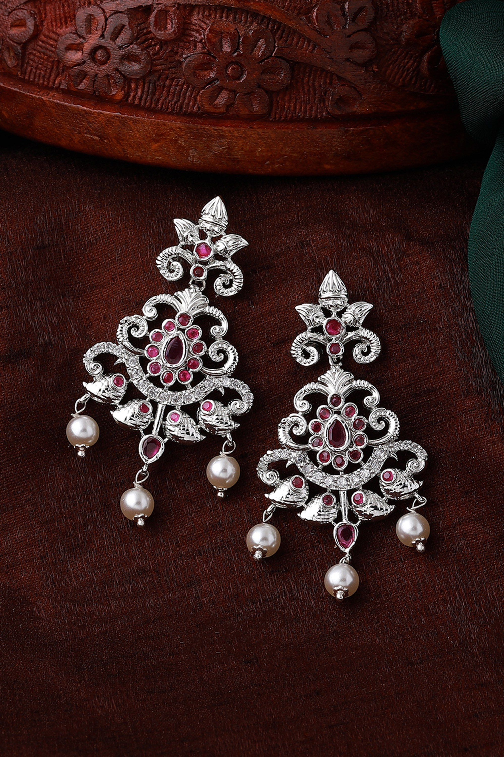 Estele Rhodium Plated CZ Swirling Symphony Earrings, featuring pearls and Ruby crystals that beautifully swirl in an elegant design, perfect for enhancing any evening look or special occasion.