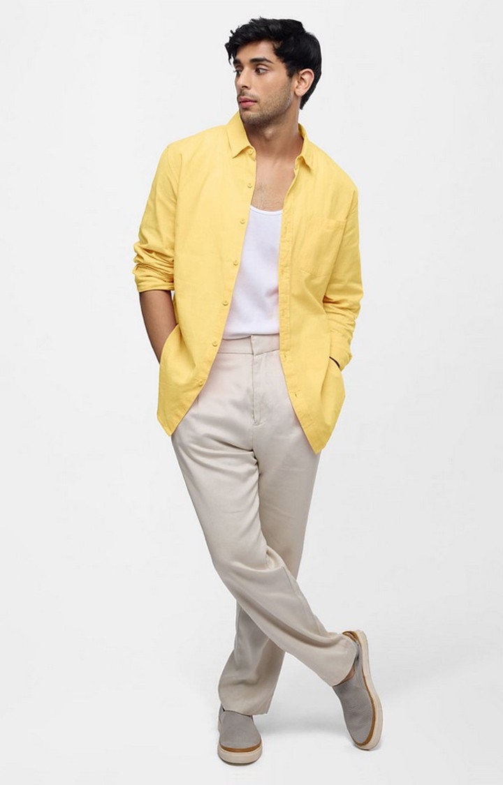 Man in Yellow Long Sleeve Shirt and White Pants Posing on Concrete Floor ·  Free Stock Photo