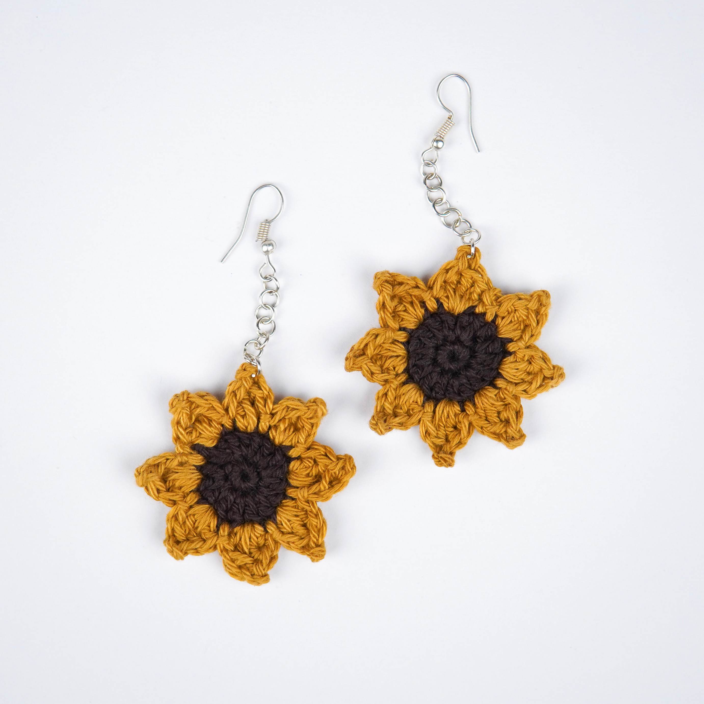 Close-up of AHG's Sunflower Crochet Earrings. Delicate details for a touch of summer.