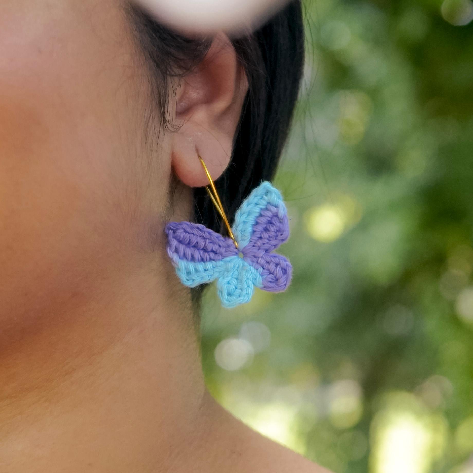  Model wearing the Blue & Purple Titli Crochet Earrings by A Handcrafted Gaatha, showcasing their whimsical elegance as they flutter with movement.