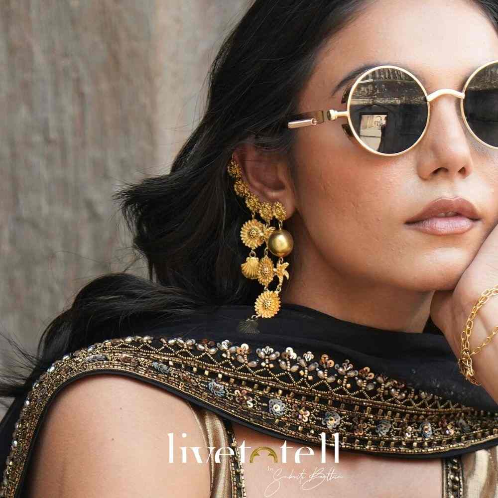 - Gold plated Jugni Pataka earcuffs with floral chaton detailing - Handcrafted earcuffs from Jaipur with cascading elements - Lightweight statement earrings in dual-wrap silhouette - Bold Indian ear jewellery for weddings and cocktail nights