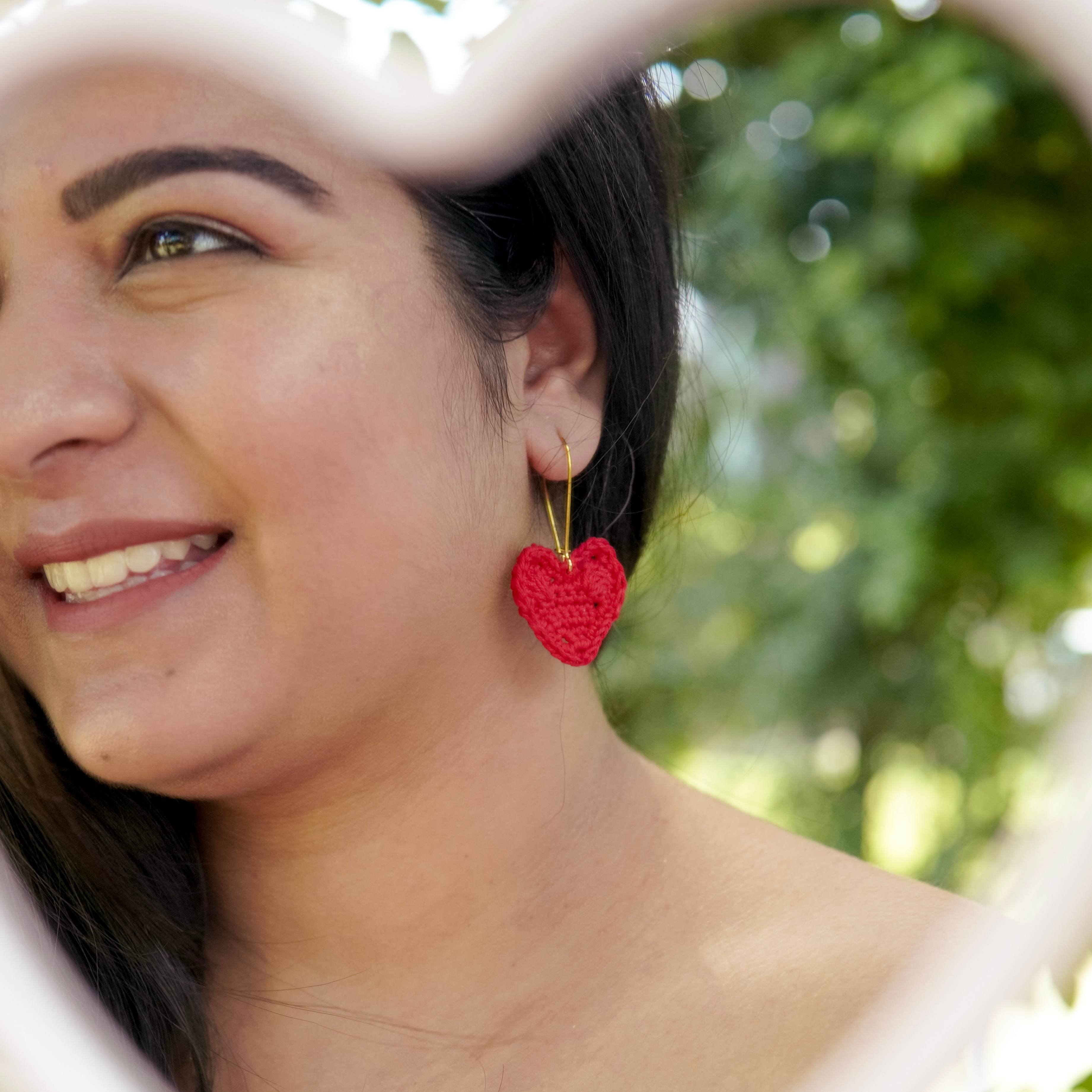  Adorable crochet heart earrings being worn by a model, showcasing style.