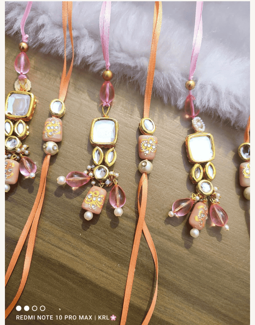 Jadau couple rakhi with peach motif and hanging