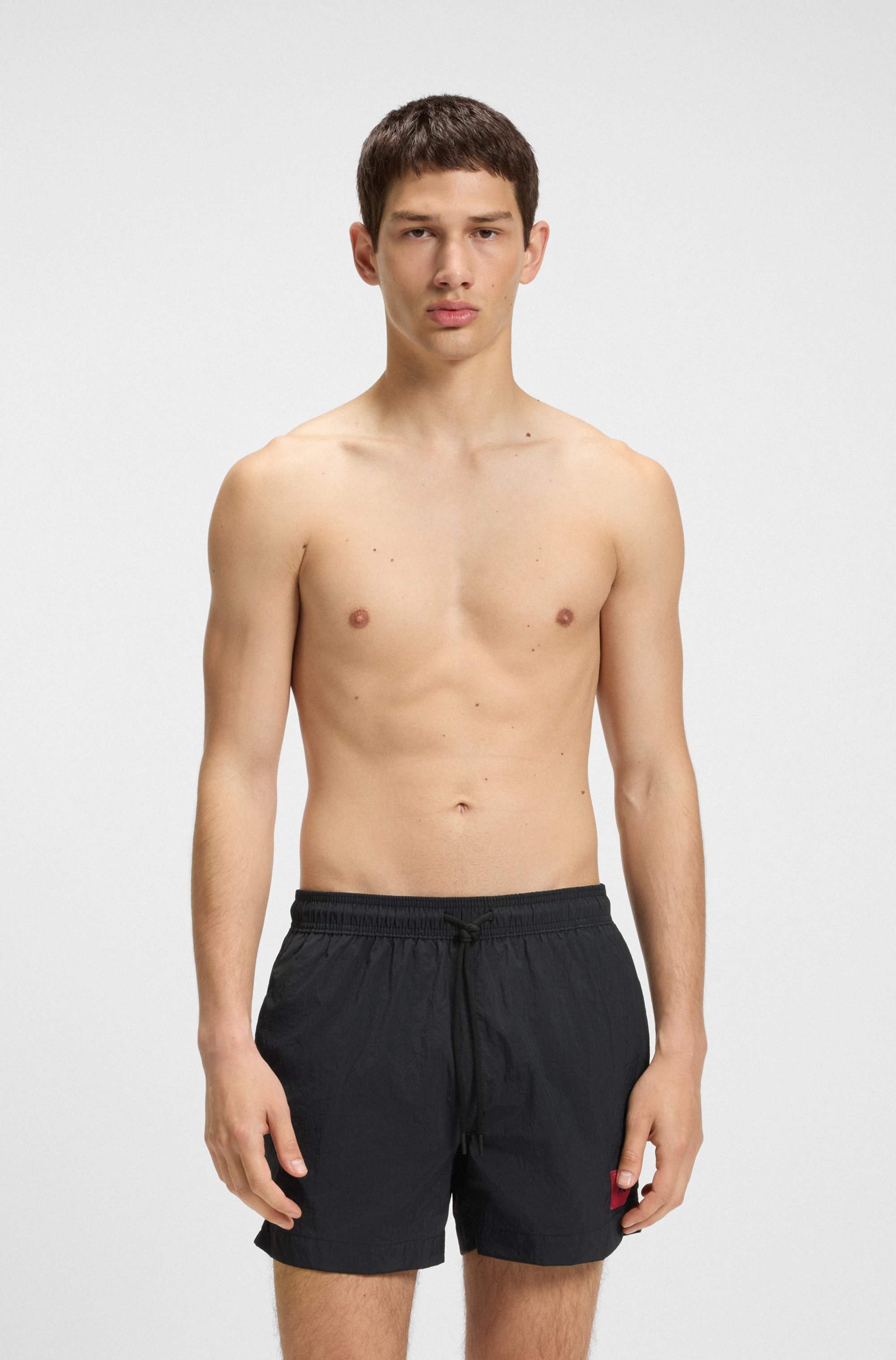 Fully lined swim shorts with red logo label