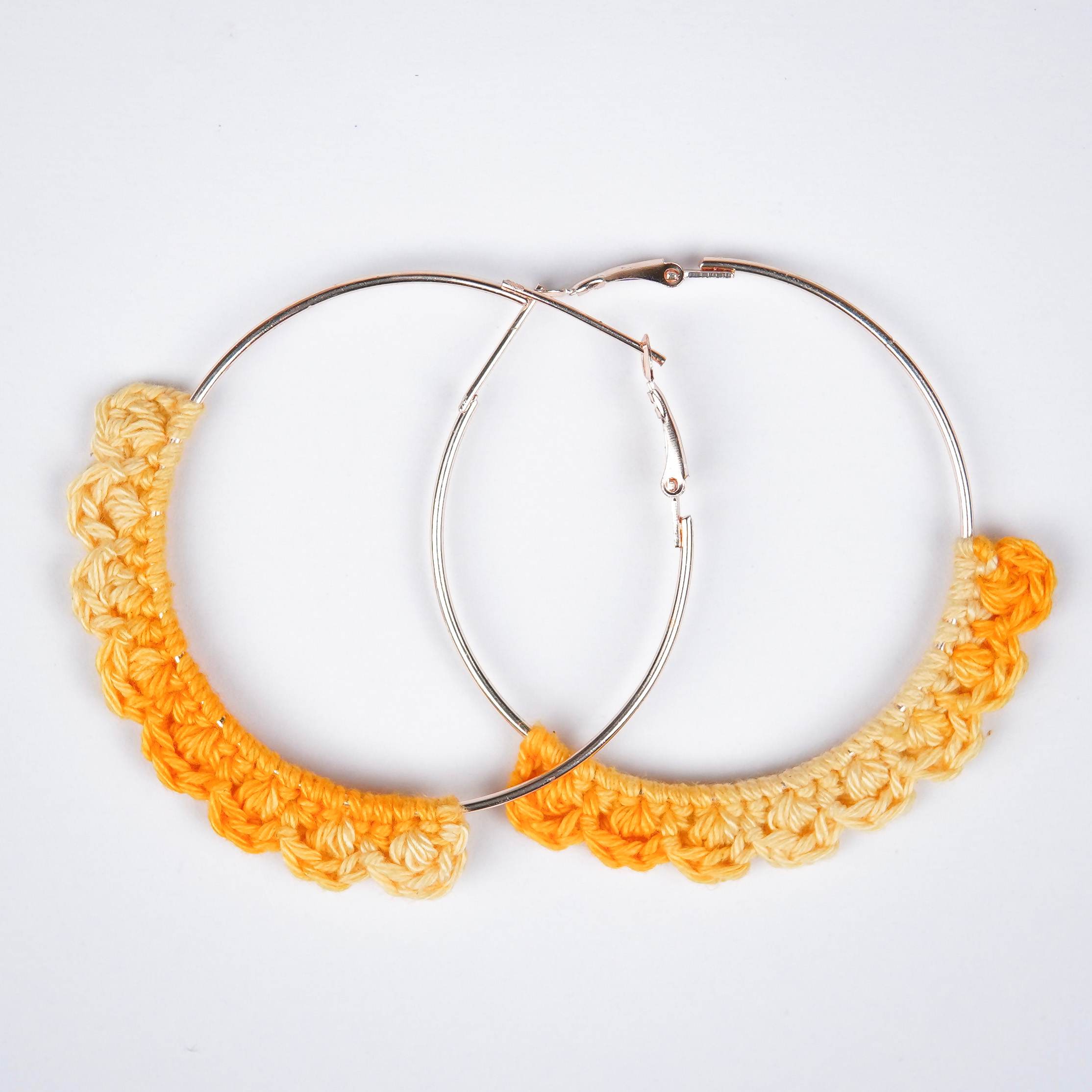 Close-up of AHG's Yellow Crochet Nazakat Hoops. Delicate crochet adds a touch of sunshine!